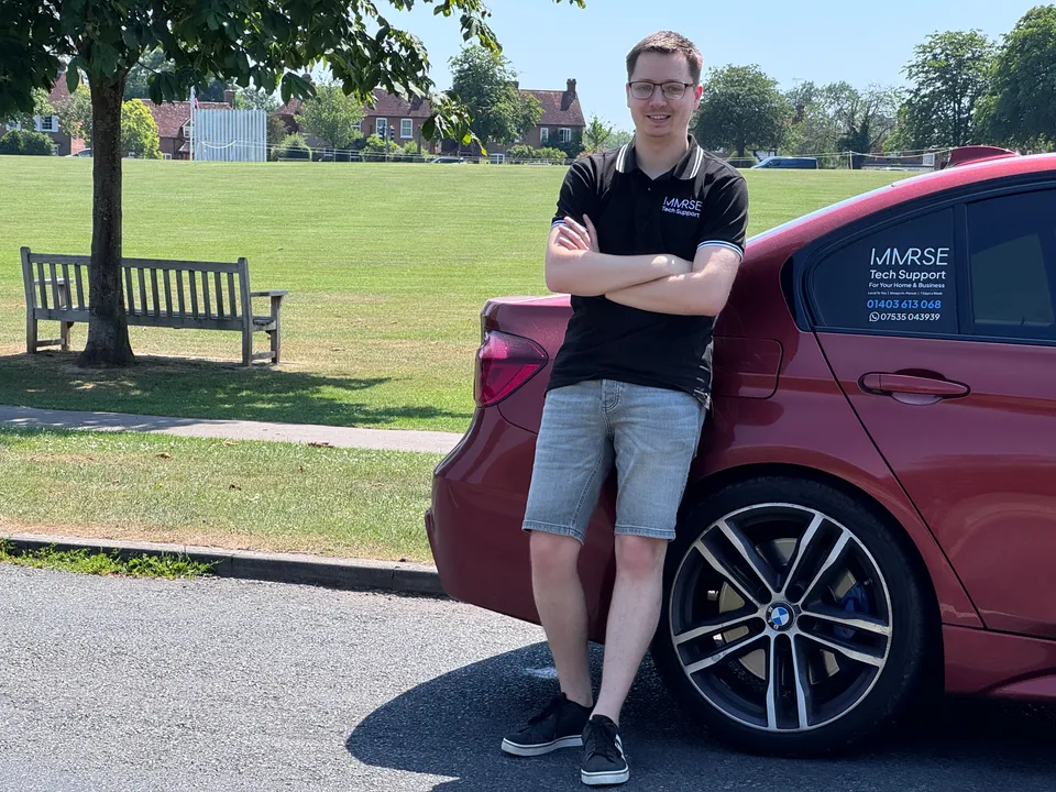 Chris standing beside the Immrse car on a village green